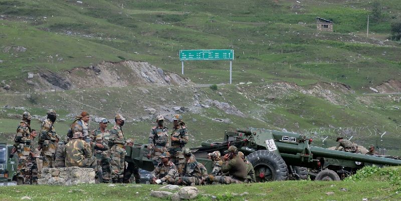Indian army soldiers rest next to artillery guns at a makeshift transit camp before heading to Ladakh, near Baltal, southeast of Srinagar, June 16, 2020. REUTERS/Stringer